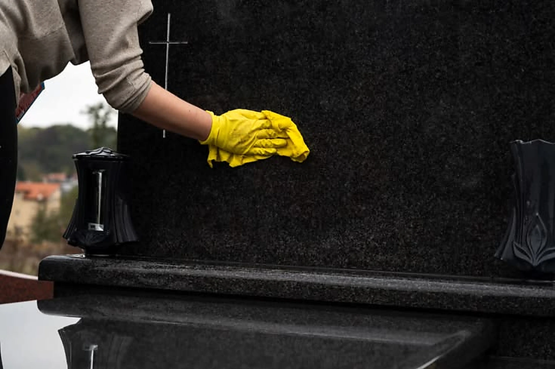 Wiping the face of a polished dark granite headstone